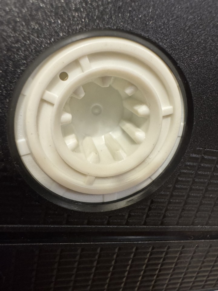 Nahaufnahme eines weißen Plastikteils mit Zähnen, das auf einem schwarzen Hintergrund zu sehen ist.